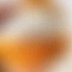 Hands use a needle and orange thread to make a blind stitch to close the opening of a fabric orange and white basketball