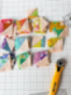 colorful half square triangle units with a yellow rotary cutter