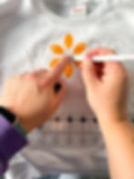 A person tracing letters on a DIY sweatshirt