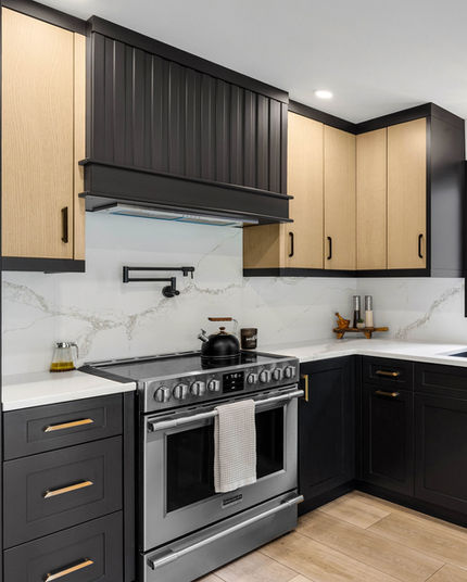 Black base cabinets with white oak uppers and custom slatted hood with black end panels