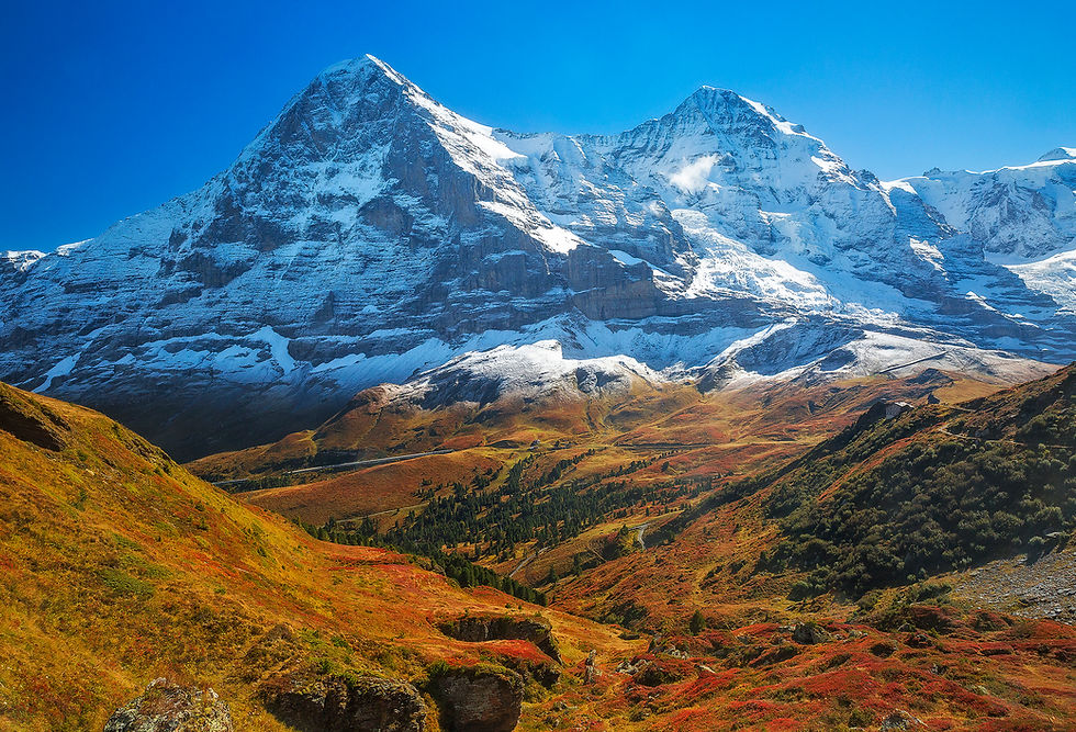 The Eiger and Monch of the Jungfrau region tower high above the tundra below. Photographed by Chase Dekker.