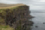 A hiker stands on the edge of an enormous cliff in Latrabjarg on Chase Dekker's Iceland photography workshop.