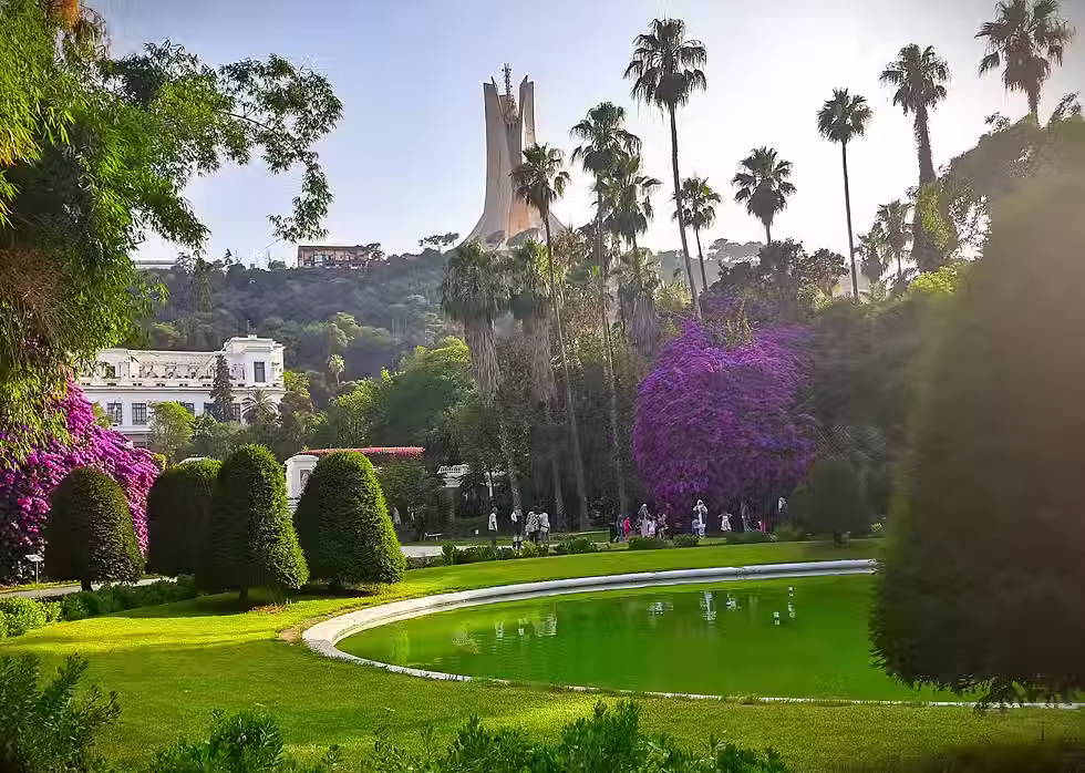 The Martyrs Memorial towering over the lush palms of the Algiers Botanical Garden