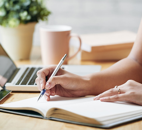 unrecognizable-woman-sitting-desk-indoors-writing-planner.jpg