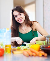 Happy-woman-cutting-vegetables Freepik.j