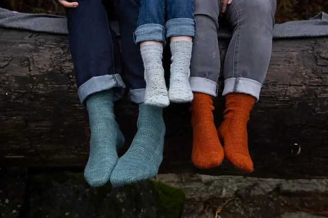 family of three modelling hand knit socks