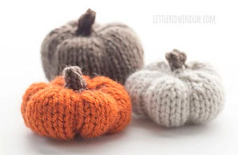 Three knitted pumpkins in orange, gray, and beige on a white background. Text on top reads: littleredwindow.com. Cozy and autumnal mood.