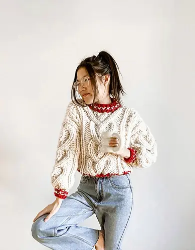 woman in glasses and loose jeans wearing chunky knit cable pullover sweater