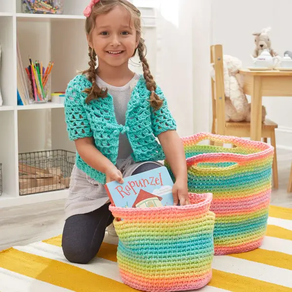 Pastel striped colorful baskets with child model storing books in basket.