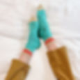 legs on bed modelling blue socks with white toe caps and red stripes, work sock style