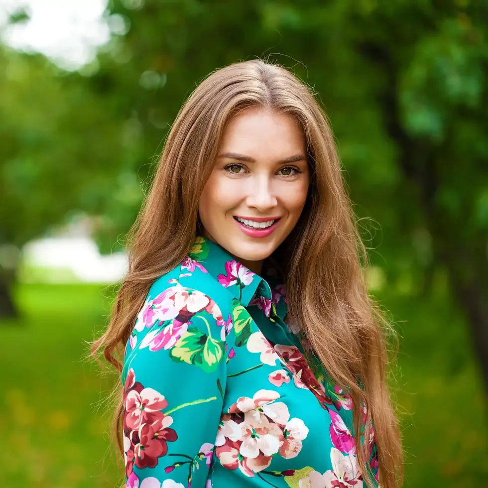 Smiling woman in a floral shirt standing outdoors
