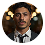 Young man in dark suit and tie with blurred background lights.