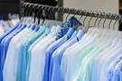 Rack of men's shirts in various shades of blue and white.