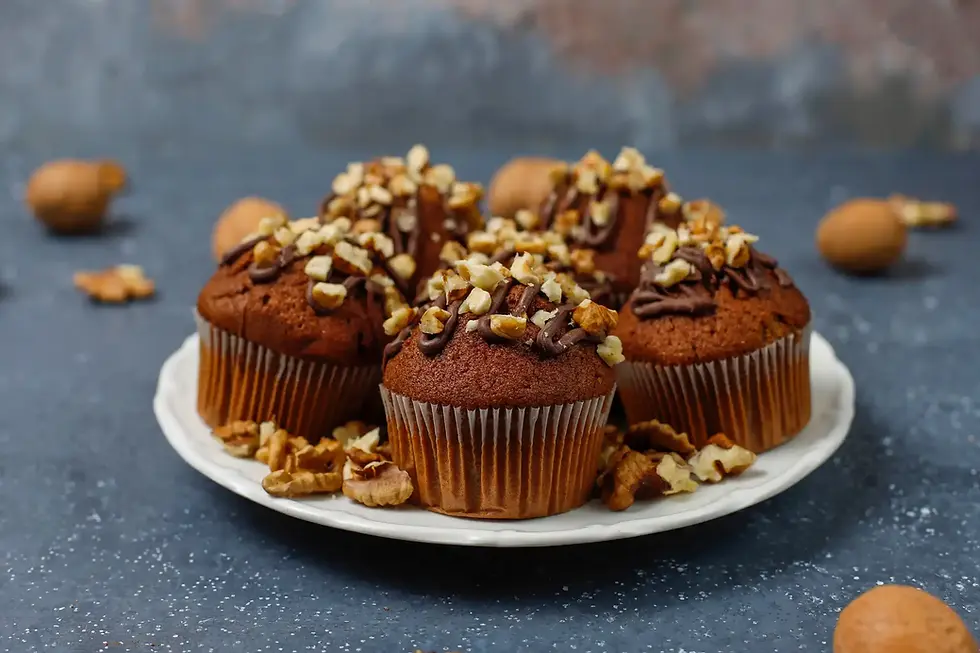 Muffins topped with walnuts on a white plate