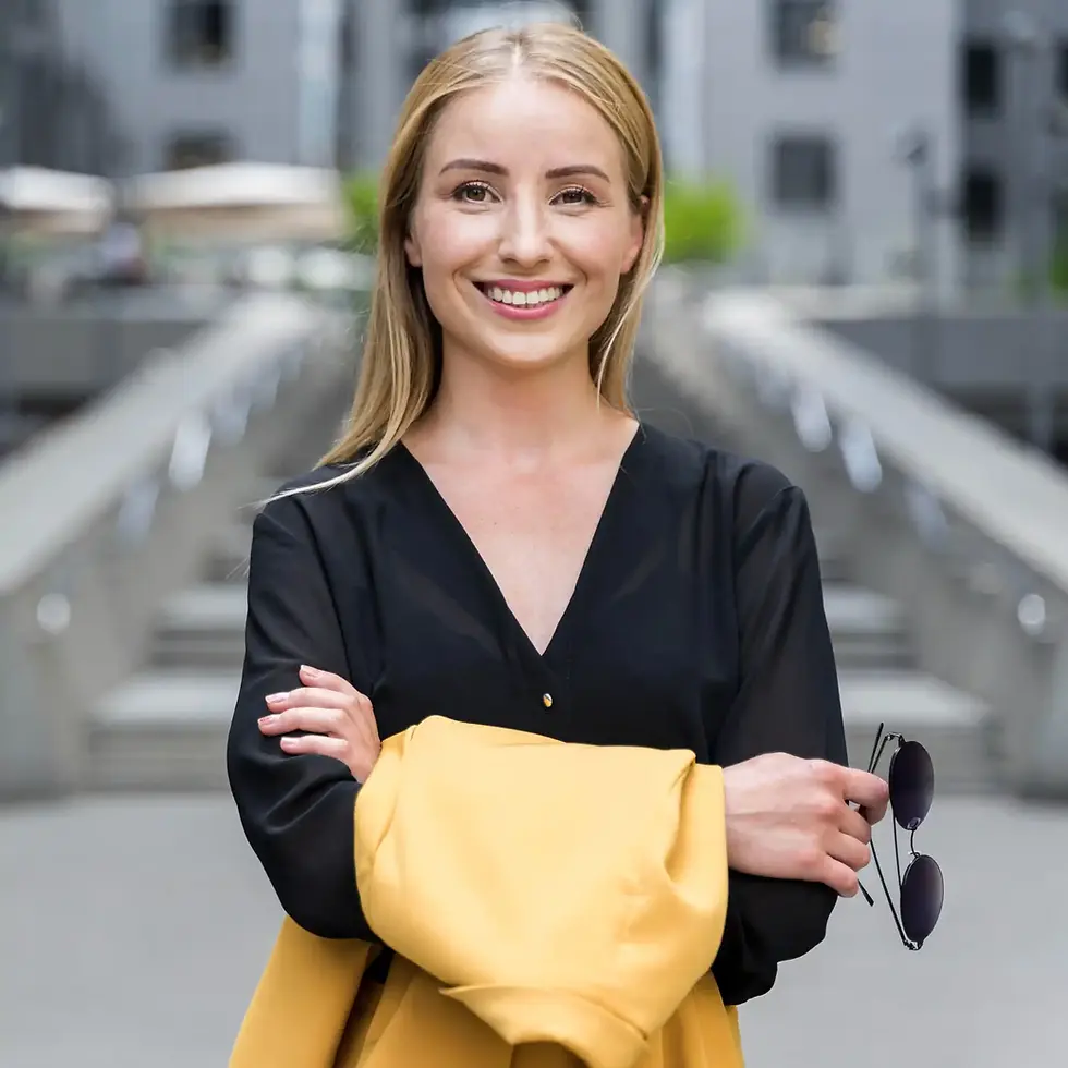 Smiling blonde woman in black shirt with arms crossed.