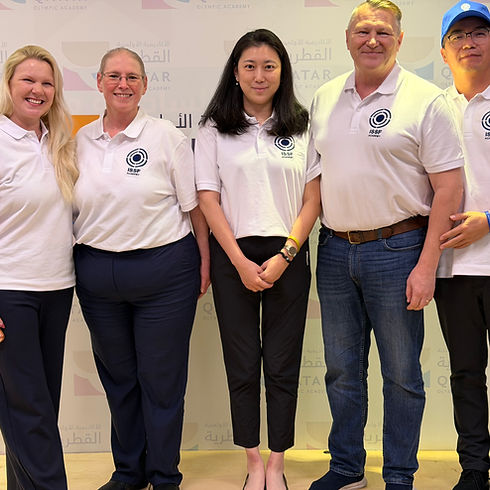 Group of shooting coaches wearing ISSF Academy polo shirts