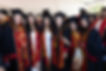 Small group of young adults wearing academic regalia
