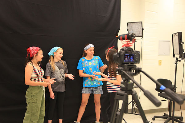 Group of campers perform scene in front of camera