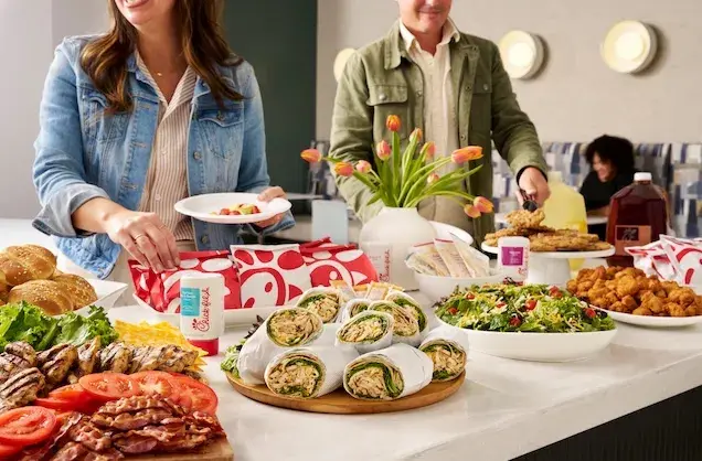 People serving catering food from Chick-fil-A