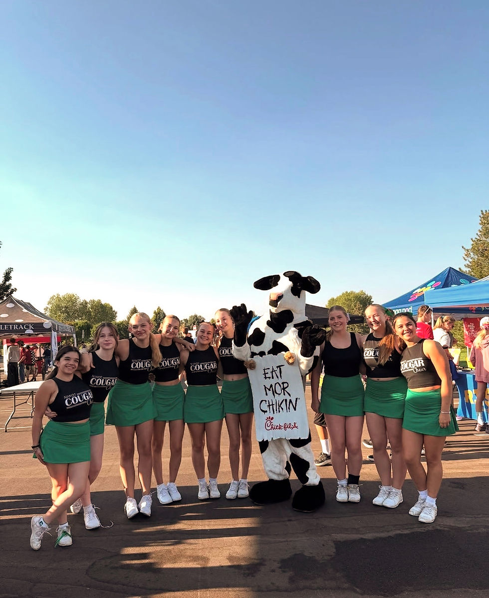 Chick-fil-A Longmont cow mascot with cheerleaders