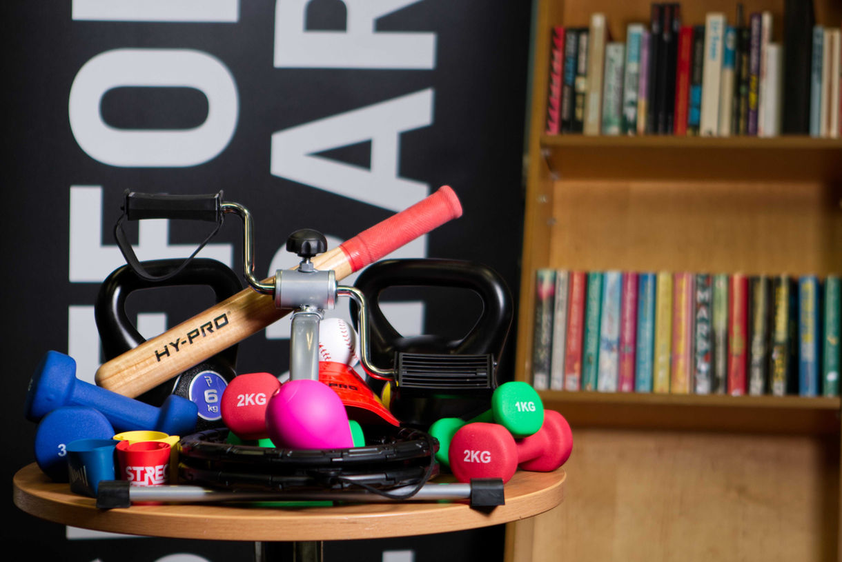 Wide shot of lots of different excercise equipment which is rentable from Suffolk Libraries. Weights, bats, Stretching bands and much more.