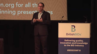 Man talking at lecturn on stage