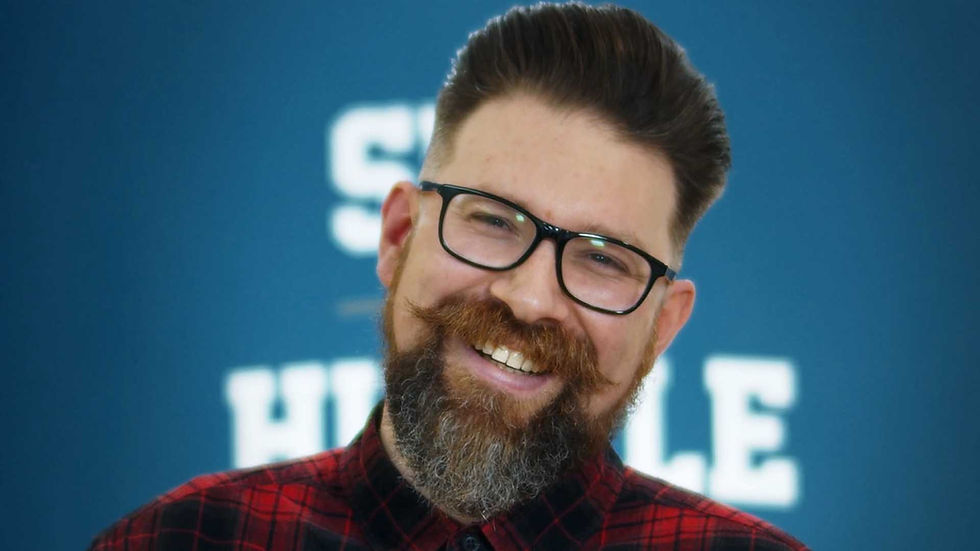 Handsome bearded gentleman smiling at camera after the barbers