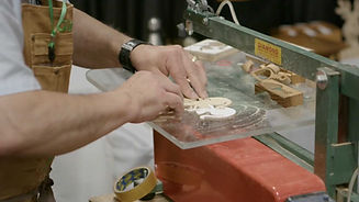 Close up of man cutting puzzle on a saw