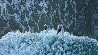 Birds eye view of 2 surfers boading boaring in the sea