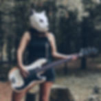 A woman wearing a paper mask holding a guitar.jpg