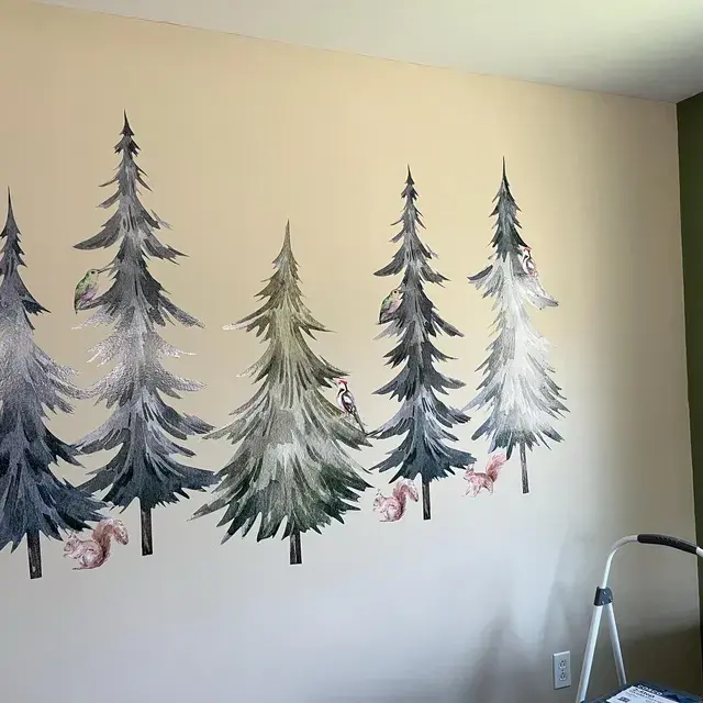 Bezaubernde Wald-Wandaufkleber mit hohen Kiefern, verspielten Eichhörnchen und Kolibris, die eine heitere Waldlandschaft an einer neutral getönten Kinderzimmerwand schaffen.