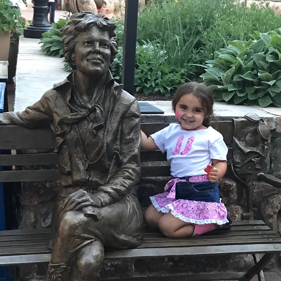 My daughter posing with a beautiful statue of Amelia Earhart in Colorado.