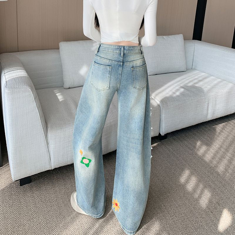 レトロな刺繍とビーズがあしらわれた、ゆったりとしたカーブシルエットのジーンズ