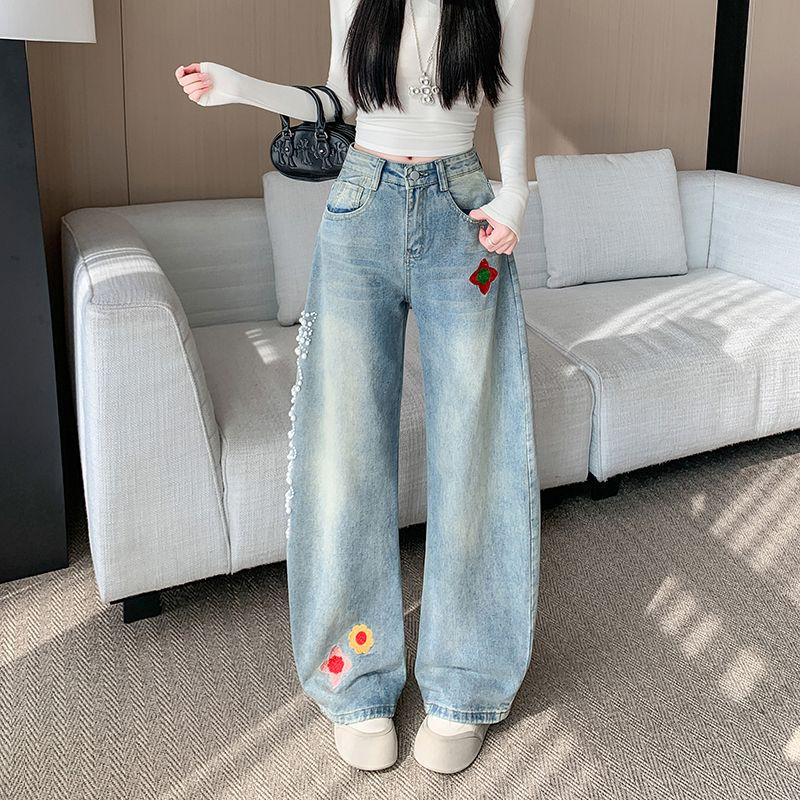 レトロな刺繍とビーズがあしらわれた、ゆったりとしたカーブシルエットのジーンズ
