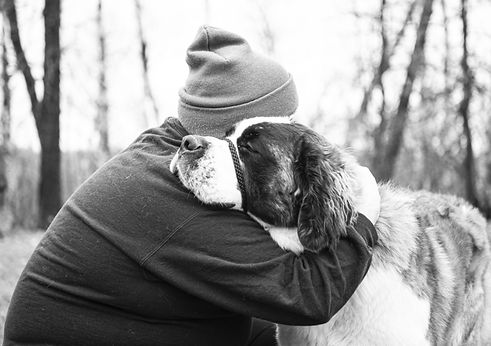 Dog Trainer Grayon Butler hugging a St Bernard