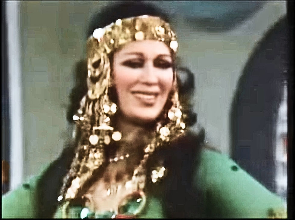 Azza Sharif performing a Tunisian dance, dressed in stage version of traditional clothing and a headpiece.