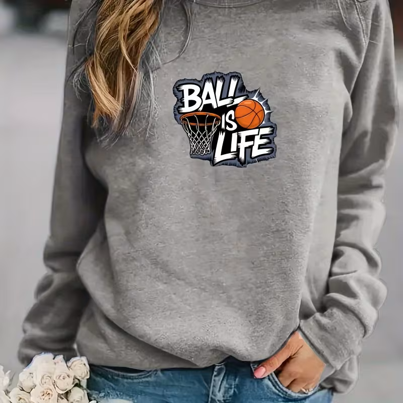 Thumbnail: Gray sweatshirt featuring a bold “Ball Is Life” graphic with a basketball entering a hoop, styled in graffiti lettering.
