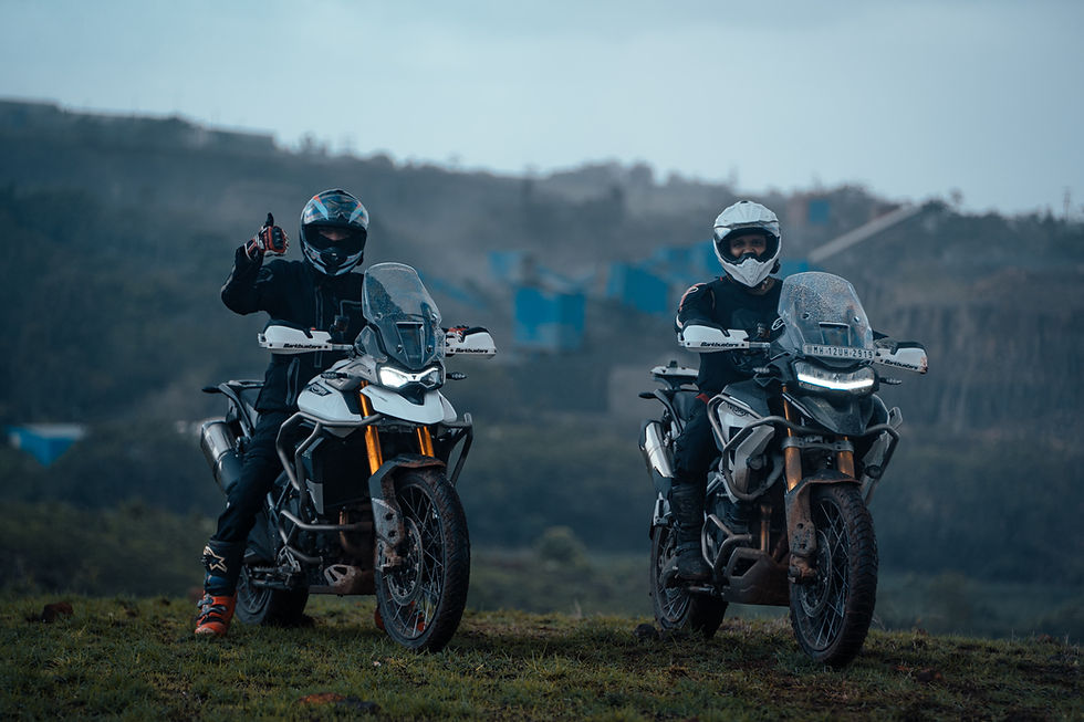 Two bikers posing on motorcycles, ready for adventure on a cloudy day.