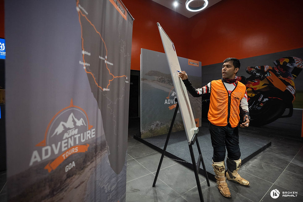 Man points to adventure map display for Goa tours; KTM adventure tours.