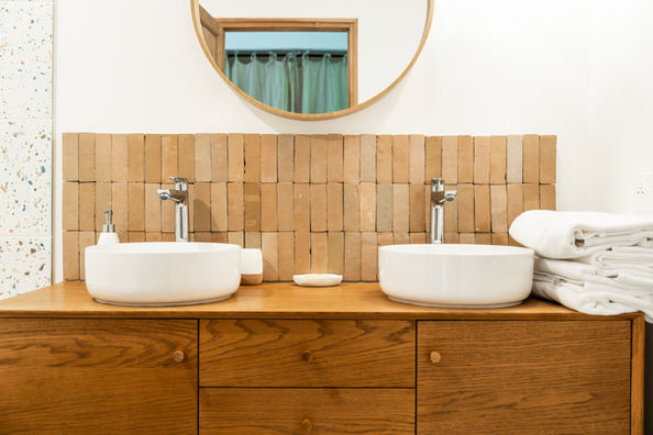 Salle de bain avec double vasque et meuble en bois dans le gîte Le Singulier, location de vacances 8 personnes dans le Jura