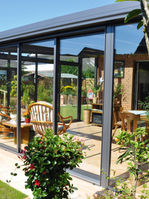 Large conservatory glasshouse on terassed house with red brick walls (different viewpoint)