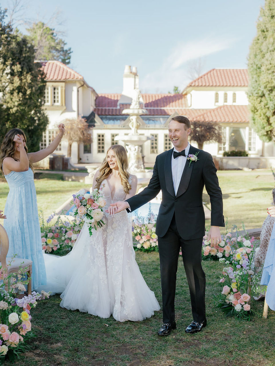 bride and groom walk down the outdoor aisle as a married couple