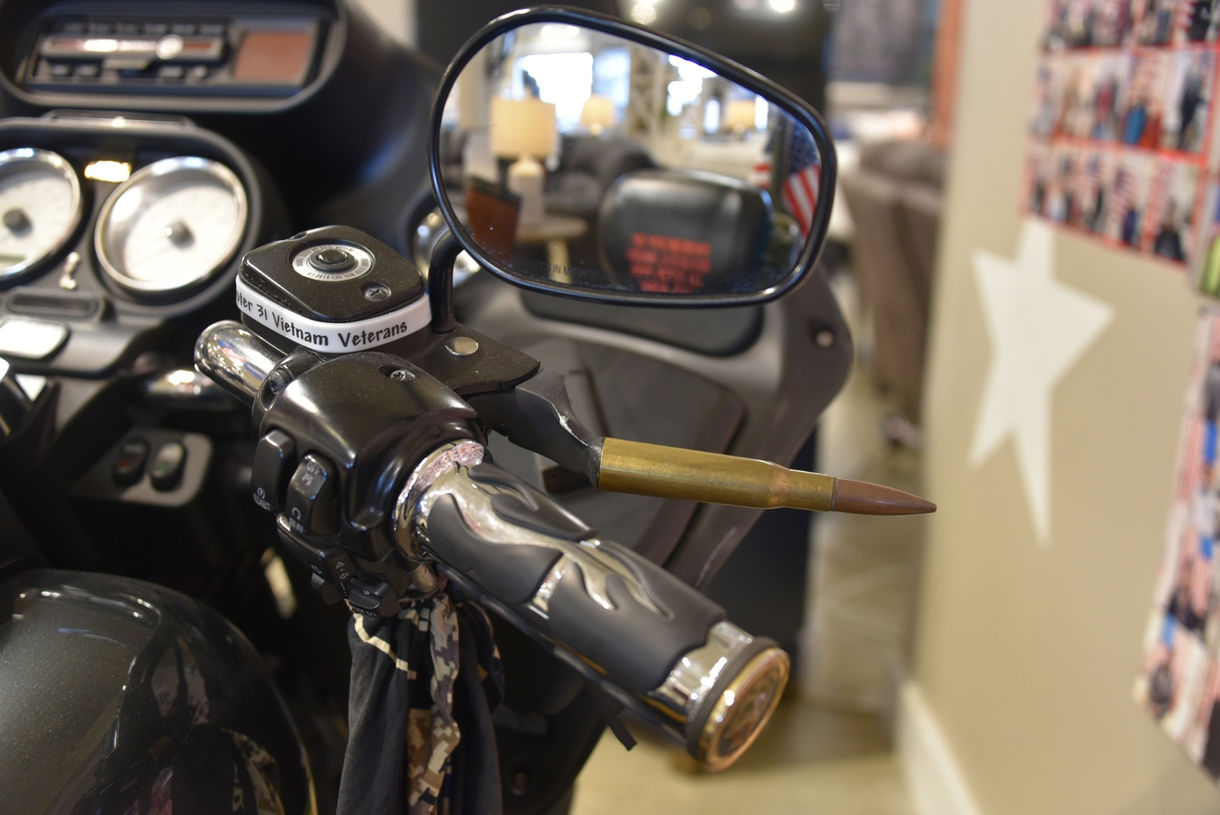 Close-up view of side mirror with bullet casing positioned above the handle.