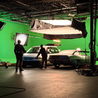 Film crew working around car to simulate movement and environmental lighting