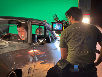 BTS of Gaffer lighting a thriller short film on a greenscreen stage in Atlanta with moody tones