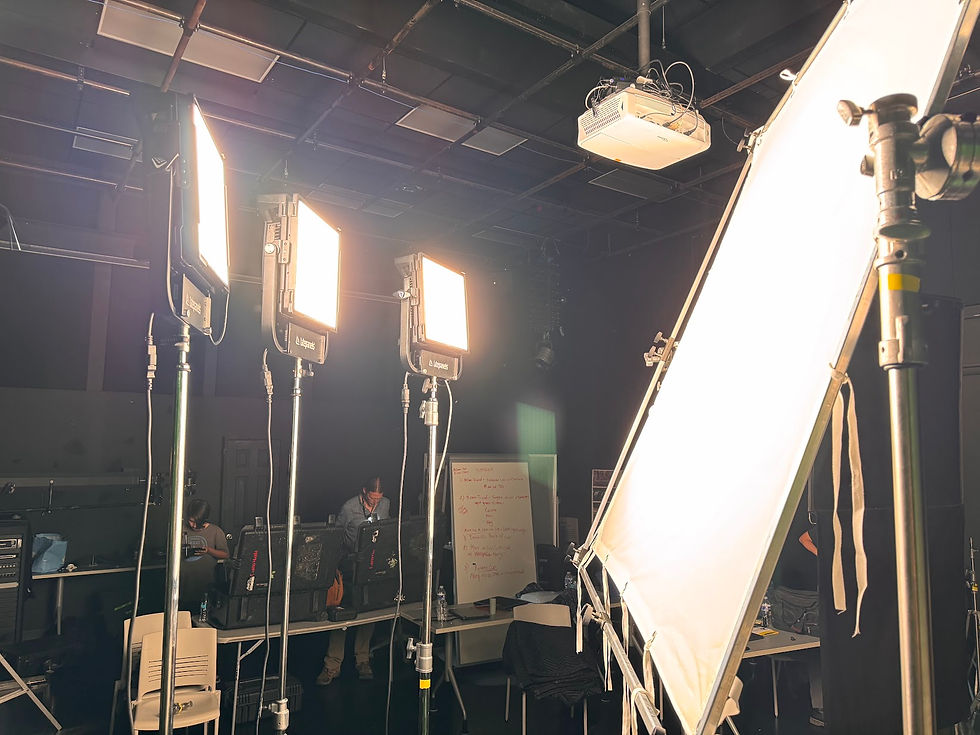 Large diffusion frame and film lights set up on a dark soundstage for soft lighting during a documentary reenactment production.