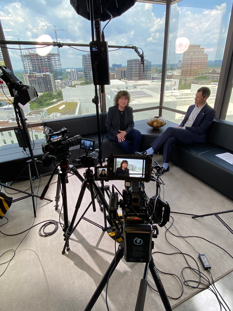 Behind the scenes of a video shoot in a high-rise in Atlanta, featuring professional cameras and lighting equipment set up for filming