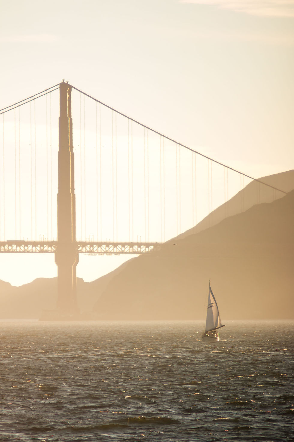 A photo of a sailboat next to Golden Gate Bridge