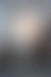 A lamp stands front and center in a room filled with eclectic modern furtniture