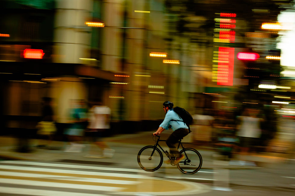 A man on his bicycle speeding through the street
